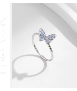 Macro view of s925 silver ring featuring a butterfly set with light blue opal stones