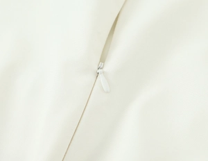 Détail en gros plan de la fermeture éclair invisible blanche sur la robe à rayures