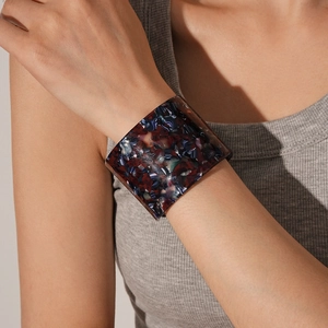 Close-up of vintage resin open cuff with red, blue and white tortoiseshell texture