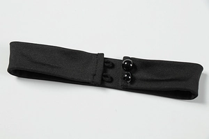 Detail of the black fabric neck choker featuring double glossy buttons and elastic loops