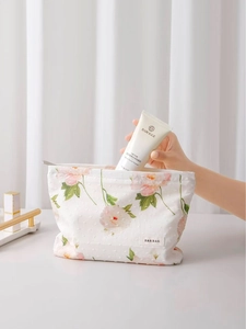 Beauty case in cotone a fiori rosa con etichetta H & R BAG su uno sfondo bianco