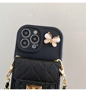 Detail of black iPhone case featuring a quilted leather card slot and golden butterfly accent