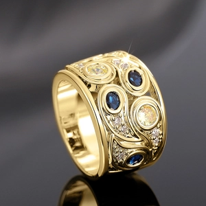 Gros plan détaillé d'une bague baroque dorée avec des pierres bleues et jaunes