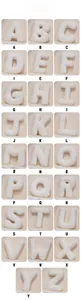 Grid display of 26 alphabet plush pillows in soft white sherpa fabric for home decor
