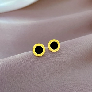 Macro shot of gold stainless steel stud earrings with shell inlay and Roman numerals