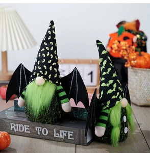 Close-up of Halloween gnome dolls with green beards and bat wings on a cozy background