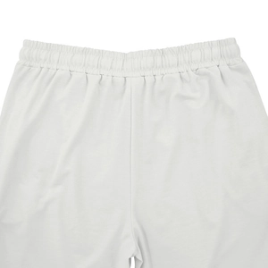 Close-up detail of white knitted sports trousers featuring an elastic waistband design
