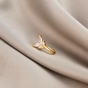 Golden butterfly nose clip with marquise zircons on elegant brown satin fabric