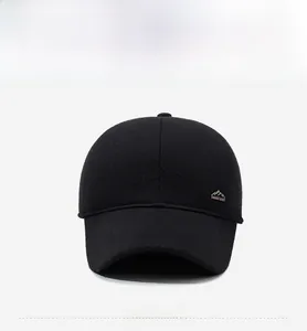 Detailed view of winter wool baseball cap with metallic mountain peak emblem on black fabric