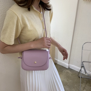 Elegant purple leather crossbody square bag styled on a female model in casual wear