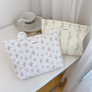 Detail of floral quilted cotton makeup bags with a soft padded texture and zipper closure
