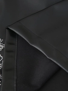Detail of matte PU leather fabric with soft lining and silver beaded embellishments