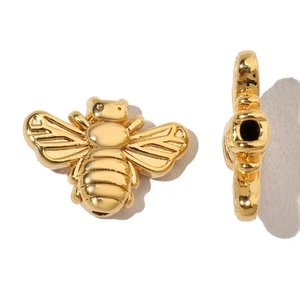 Macro view of gold bee charm pendant showing front and side views for DIY jewelry