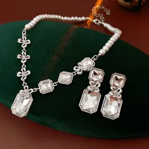 Luxury silver flower jewelry set with square crystals and pearls on velvet display