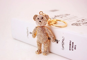 Detailed close-up of a gold teddy bear keychain fully encrusted with sparkling crystals