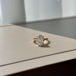 Macro shot of gold ring showing oval-cut crystal and micro-pave stones detail
