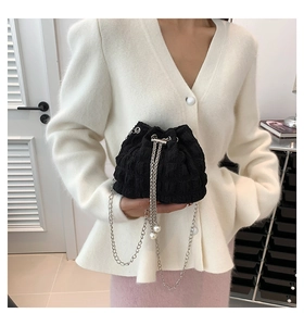 Chic black drawstring bucket bag with pleated texture and silver chain strap details