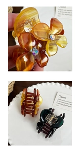 Close-up of acetic acid flower hair claw with rhinestone detail in amber and dark green