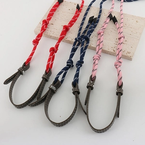 Detail of colorful woven eyeglass chains in red, blue and pink with leather accents
