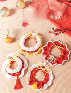 Détail de colliers en tricot rouge pour animaux avec broderie dragon et décor festif