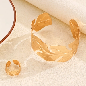 Detailed view of hollow leaf pattern gold plated adjustable cuff bracelet and ring set