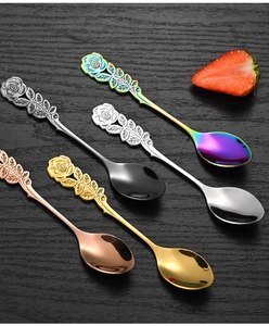 Detail of rose embossed handles on multi-colored stainless steel dessert spoons