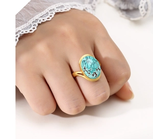 Detail of a 925 silver ring with oval turquoise stone and black matrix on model's hand