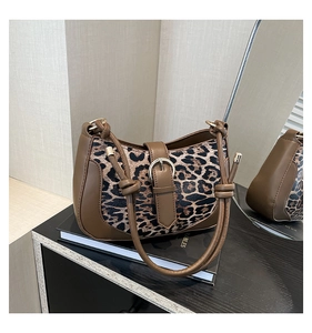 Close-up of leopard print fabric detail with premium leather trim and buckle