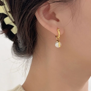 Detail view of 925 silver gold hoop earring with a white teardrop pearl pendant