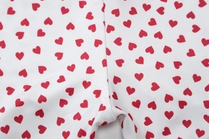 Gros plan sur le motif cœur rouge sur tissu sergé blanc avec double couture robuste