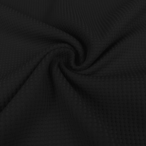 Macro shot of black waffle knit fabric texture on men's polo shirt showing honeycomb pattern