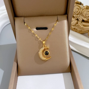 Golden titanium steel crescent moon necklace with zircon stones in a jewelry box