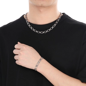 Close-up of thick silver Cuban chain necklace and bracelet set on male model