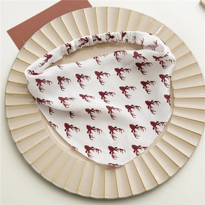 Dettaglio fascia in raso bianco con stampa corna di renna rosse su piatto ceramica