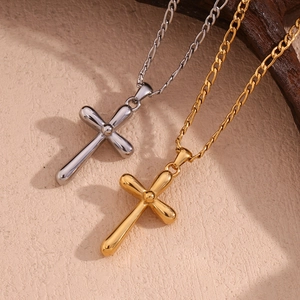 Detailed shot of polished gold and silver cross pendants on a stylish Figaro chain necklace