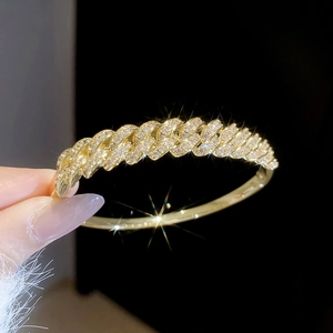 Detailed close-up of 18k gold plated hollow bangle with pavé set sparkling zircons