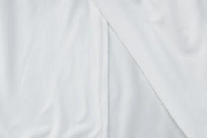 Close-up of white soft fabric texture with detailed stitching and smooth material finish
