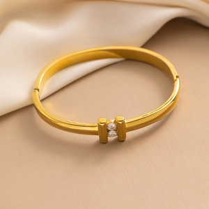 Minimalist gold titanium steel cuff bracelet featuring two vertical bars with clear zircons