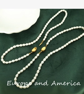 Macro shot of irregular natural freshwater pearls and golden clasp on green velvet