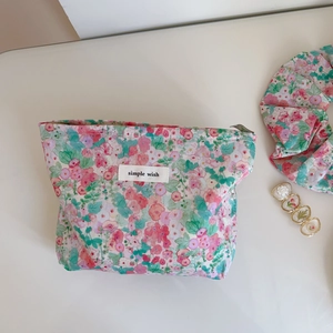Detail of pink floral cotton pouch with simple wish label and top zipper closure
