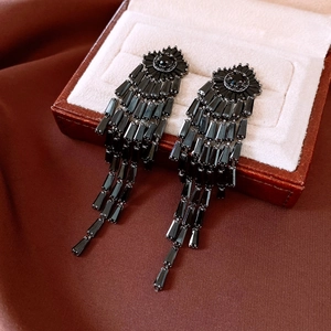 Detail of 14K gold plated long black tassel earrings with faceted crystal on silk