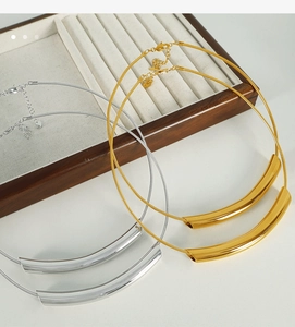 Detail of gold and silver minimalist curved tube necklaces with snake chains and lobster clasps