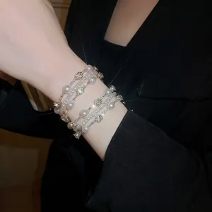 Elegant multi-layer pearl and rhinestone bracelet set in luxury French style on a model