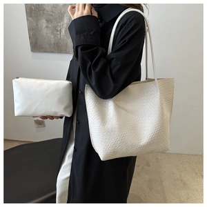 Detail of white woven texture tote bag and matching pouch on fashion model