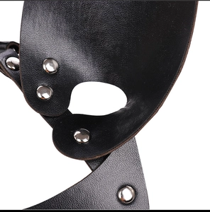 Dettaglio della pelle nera martellata con rivetti in metallo argento sulla maschera punk