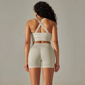 Detail view of sage green seamless yoga set featuring cross strap bra and high waist shorts