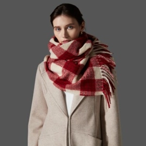 Detailansicht eines rot-beigen Karoschals mit dicken Fransen und warmer Textur