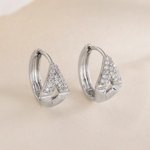 Silver geometric hoop earrings with sparkling A-shaped zircon crystals on textured fabric