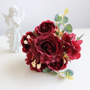 Detailed view of dark red artificial roses and hydrangeas with green eucalyptus leaves