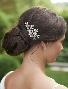 Detail view of a silver bridal hair pin set with rhinestones worn in a formal updo style
